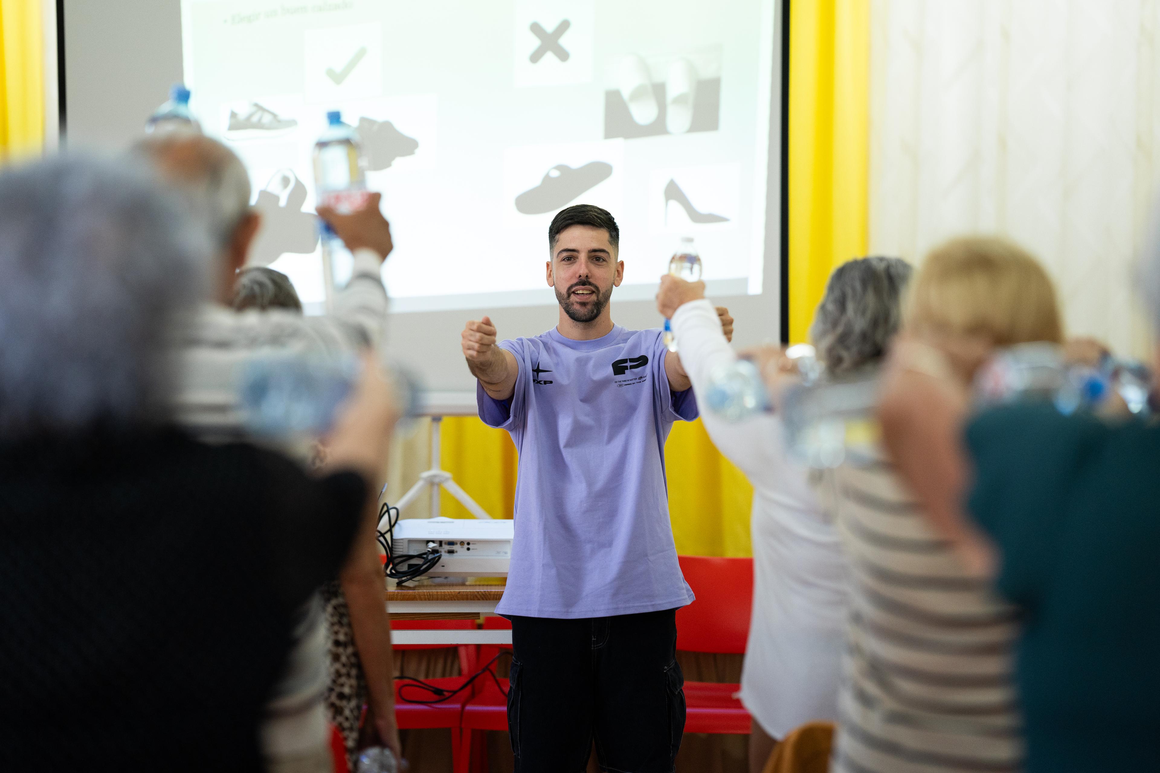 Instructor guiando ejercicios con botellas a personas mayores en taller de salud