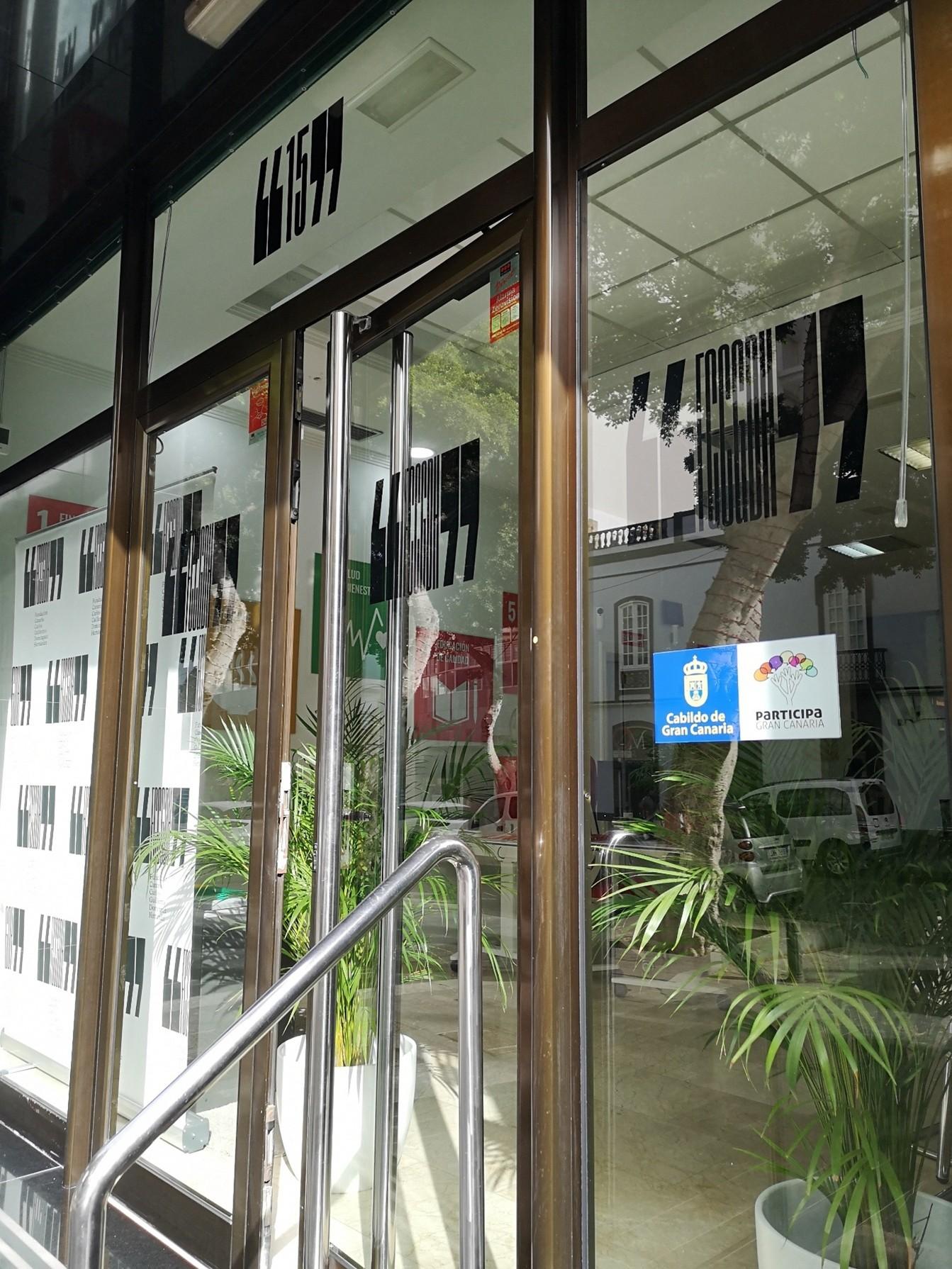 Acceso acristalado a la fundación con señalética institucional visible