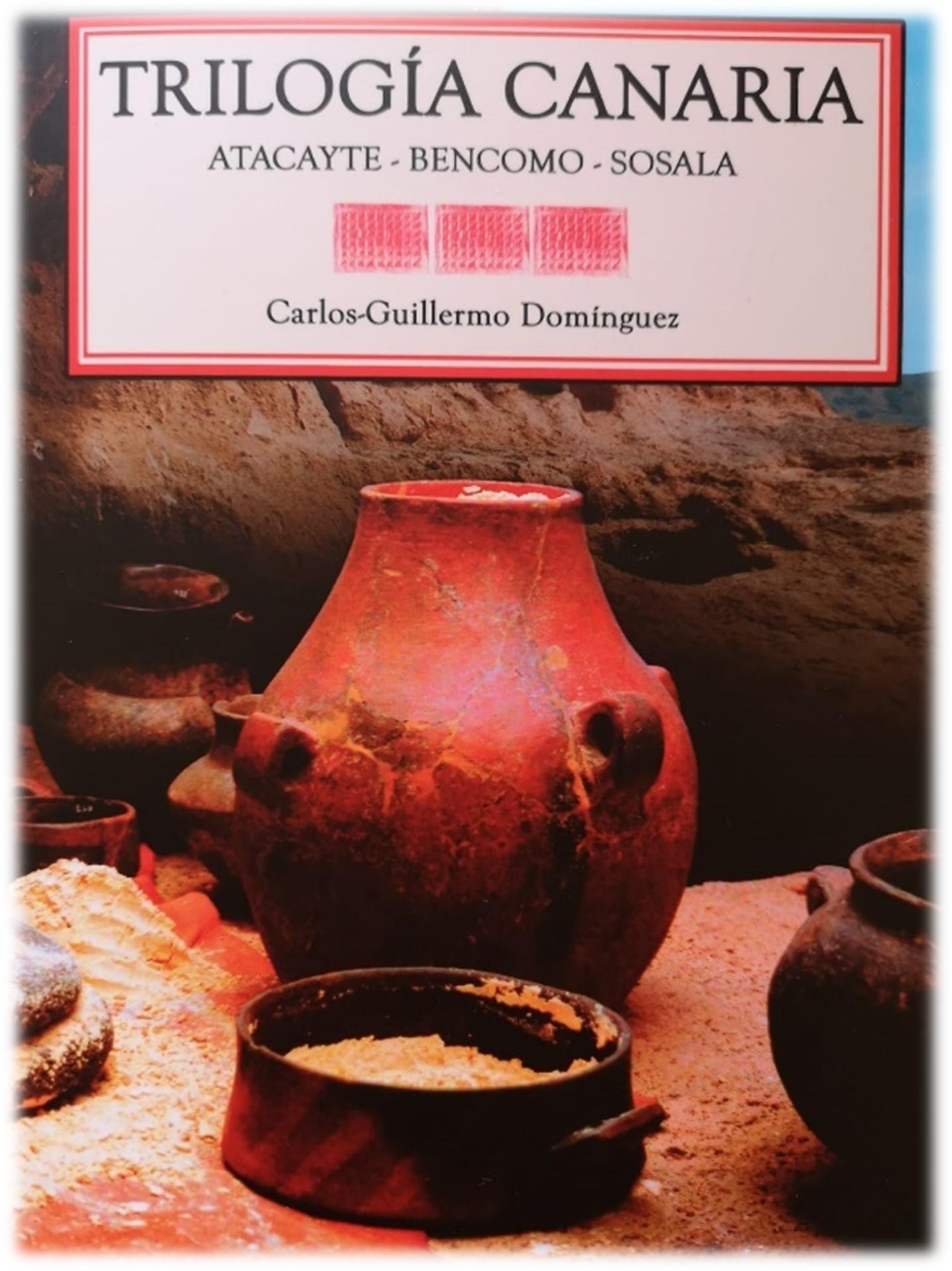 Portada del libro Trilogía Canaria de Carlos Guillermo Domínguez con cerámica tradicional en escena arqueológica canaria